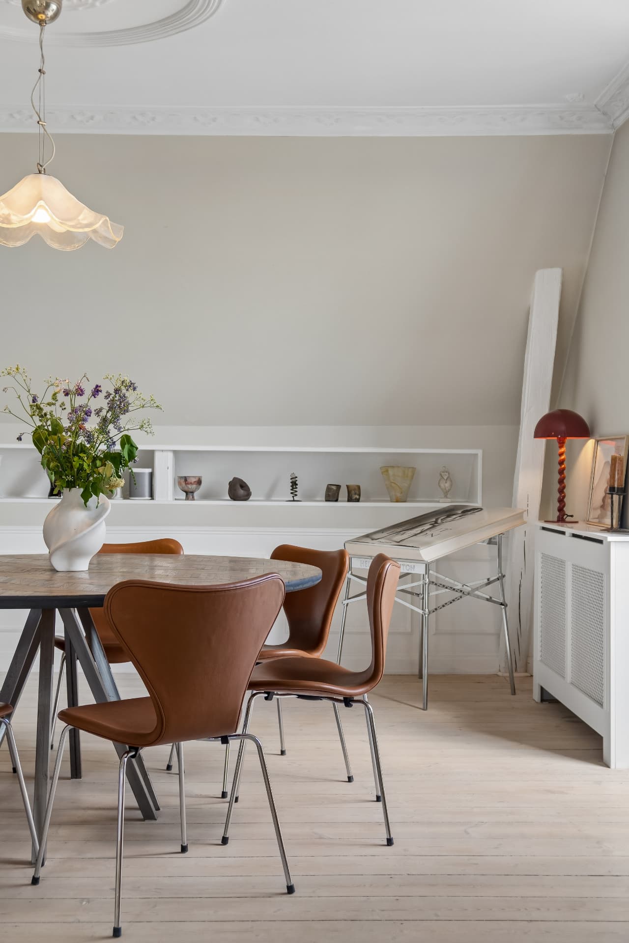 Spisebord med danske designstole og keramik i hvid niche